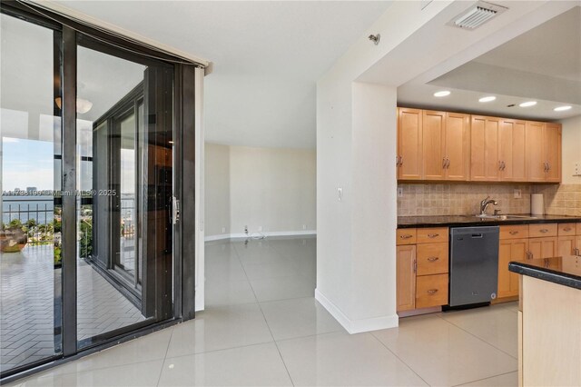 kitchen with dishwasher, sink, backsplash, light tile patterned floors, and light brown cabinets