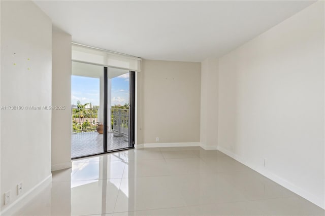 spare room with light tile patterned flooring and floor to ceiling windows