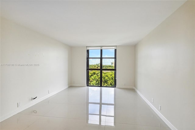 empty room featuring light tile patterned flooring and floor to ceiling windows