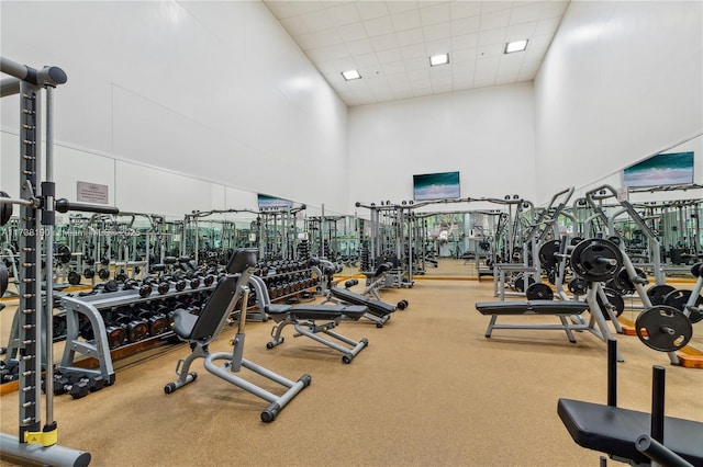 gym with a drop ceiling and a high ceiling