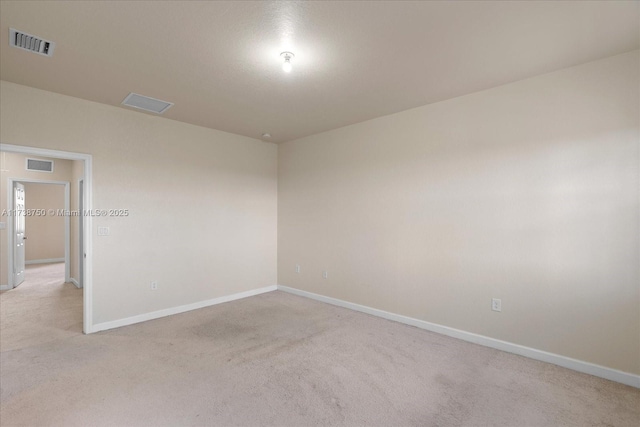 unfurnished room featuring visible vents, light carpet, and baseboards