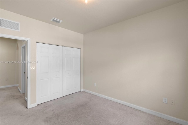 unfurnished bedroom featuring a closet, carpet, visible vents, and baseboards