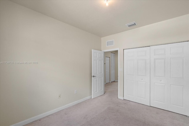 unfurnished bedroom featuring carpet floors, baseboards, visible vents, and a closet