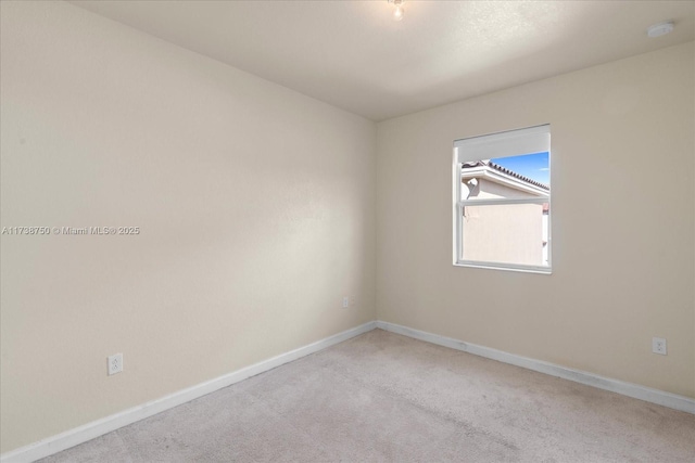 unfurnished room with carpet flooring and baseboards