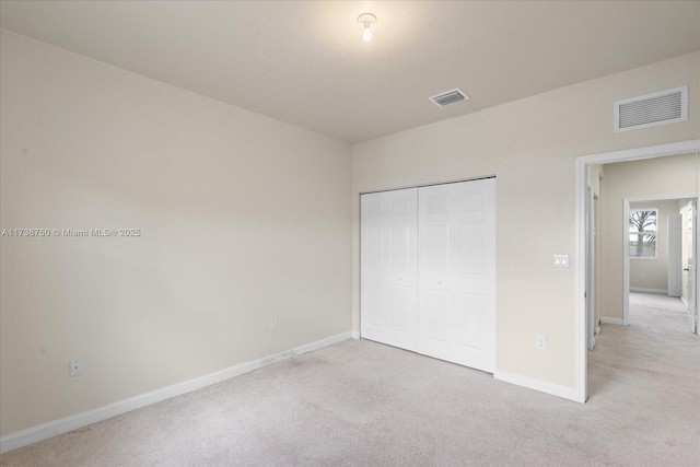 unfurnished bedroom with light colored carpet, visible vents, and baseboards