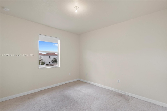 unfurnished room with carpet and baseboards