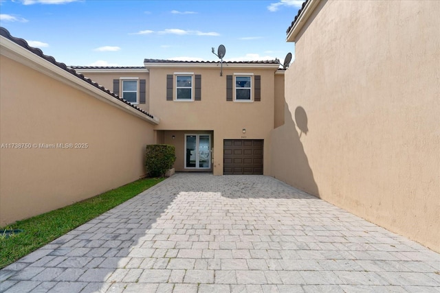 exterior space featuring a garage and decorative driveway