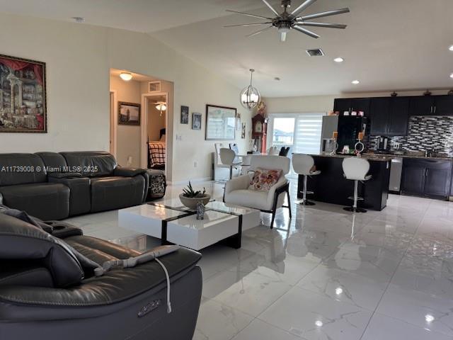 living room with ceiling fan and lofted ceiling