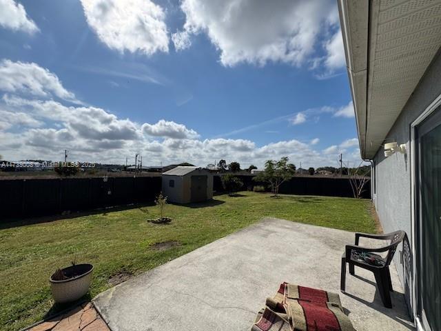 view of yard featuring a shed and a patio