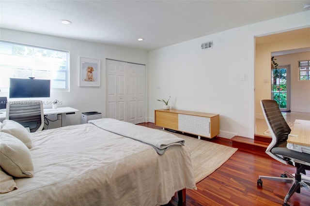 bedroom with dark wood-type flooring and a closet