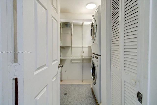 clothes washing area with stacked washer and clothes dryer