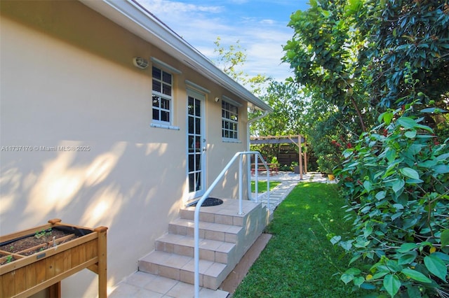 property entrance featuring a lawn