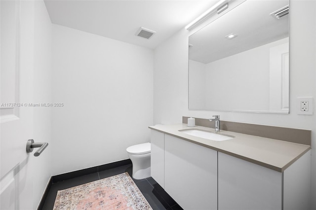 bathroom featuring vanity, tile patterned floors, and toilet