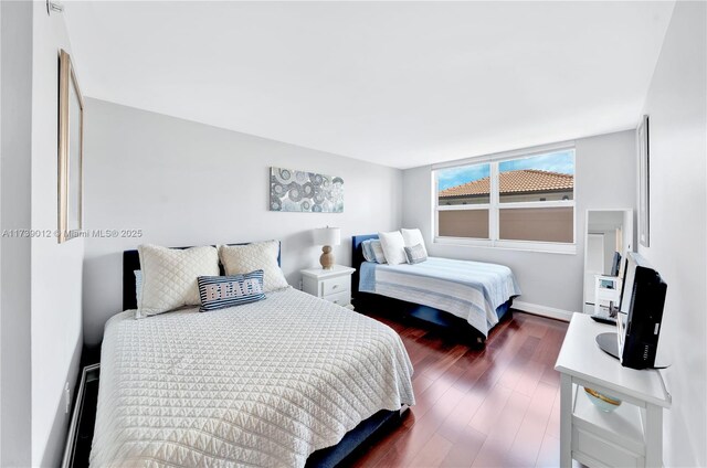 bedroom with dark hardwood / wood-style floors