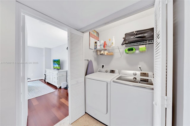 clothes washing area featuring light hardwood / wood-style flooring and washer and clothes dryer