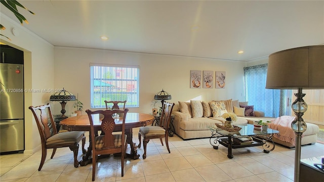 dining space with light tile patterned floors and ornamental molding