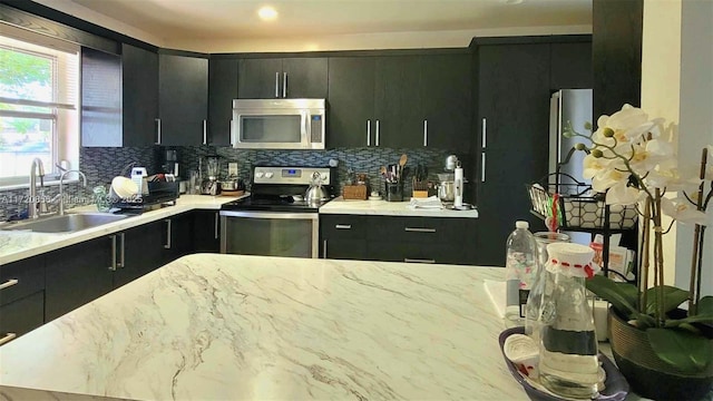 kitchen with stainless steel appliances, sink, and backsplash