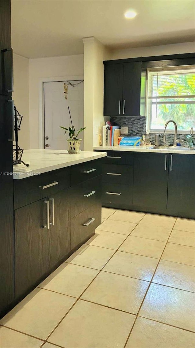 kitchen featuring light tile patterned flooring, sink, and decorative backsplash