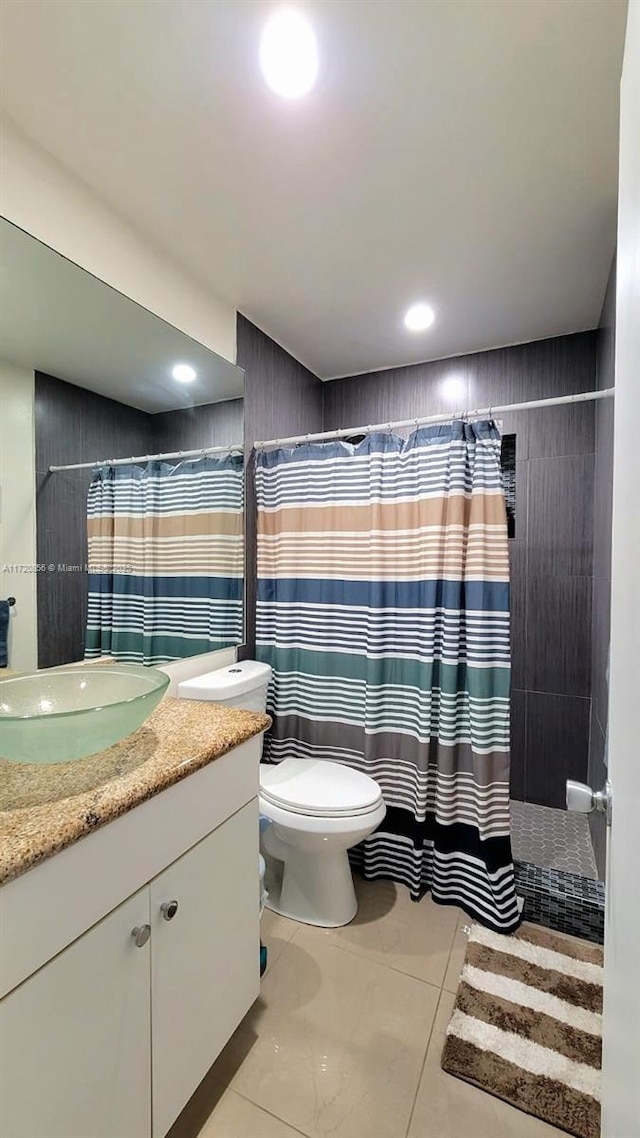 bathroom featuring a shower with curtain, vanity, toilet, and tile patterned flooring