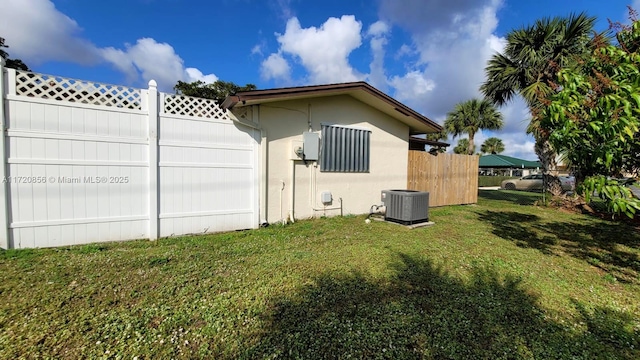 view of property exterior with central AC unit and a lawn