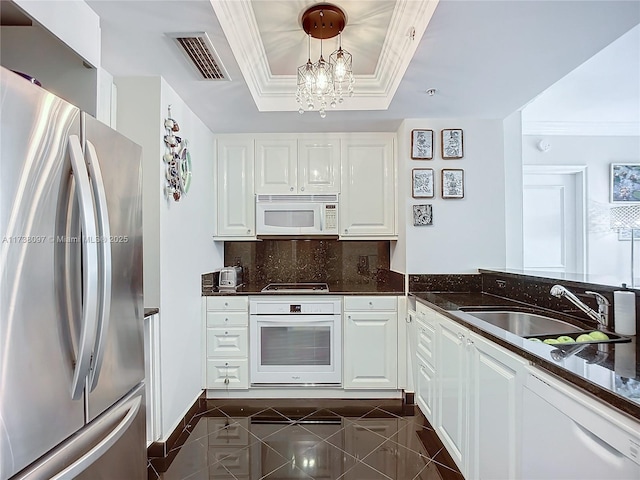 kitchen with pendant lighting, white cabinetry, sink, a raised ceiling, and white appliances