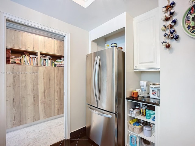 kitchen with stainless steel fridge and dark tile patterned floors