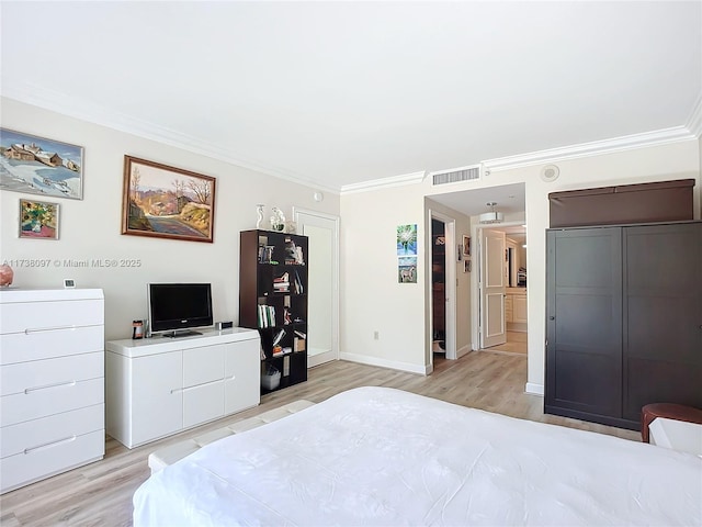 bedroom featuring ornamental molding and light hardwood / wood-style floors