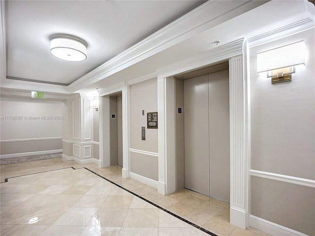 hallway with ornamental molding, elevator, and a tray ceiling