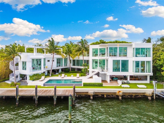 rear view of property featuring a balcony, a water view, and a patio area