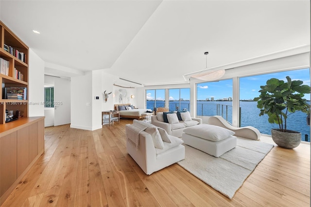 living room featuring light wood-type flooring and a water view