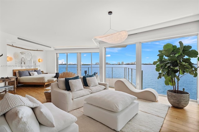 living room featuring a water view and light wood-type flooring