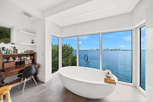 bathroom featuring a water view and a tub to relax in