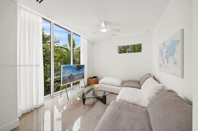 living room with expansive windows, ceiling fan, and a healthy amount of sunlight