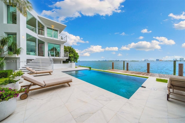 view of swimming pool featuring a patio and a water view