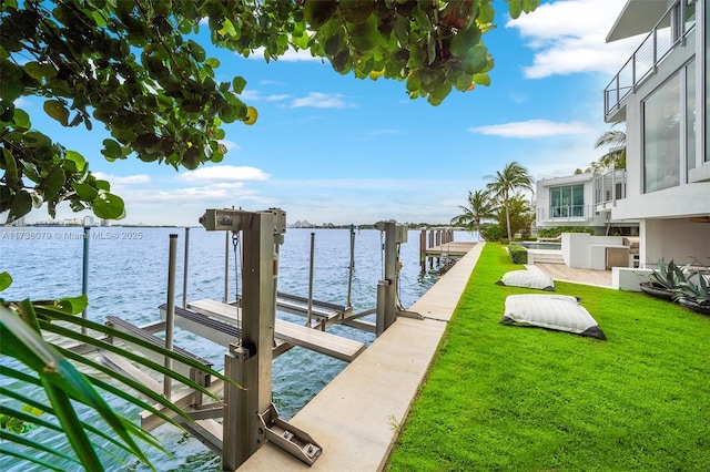 dock area with a water view and a lawn