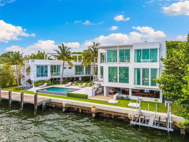 back of property featuring a patio, a water view, and a balcony