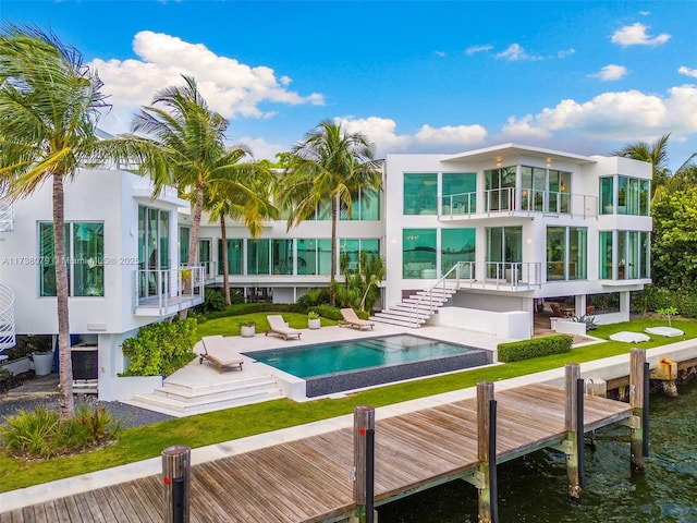 rear view of house featuring a water view, a balcony, and a patio