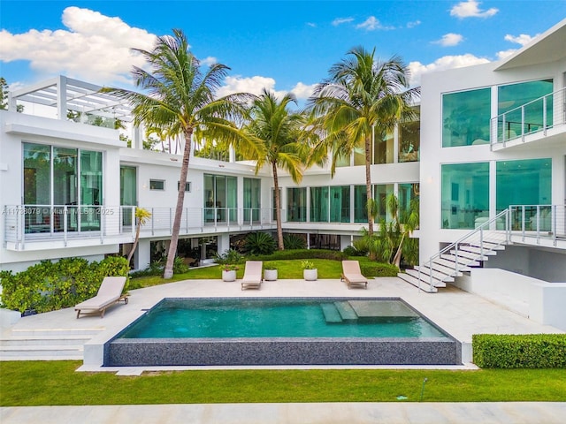 rear view of house featuring a swimming pool with hot tub and a patio area