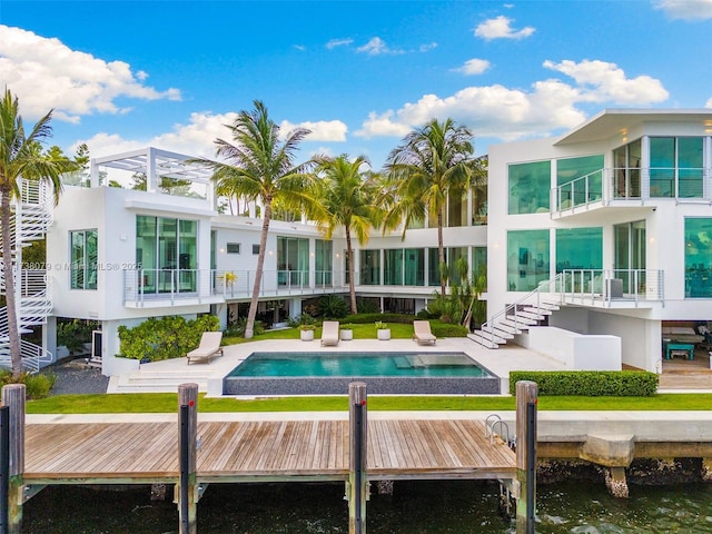 rear view of house with a water view and a patio