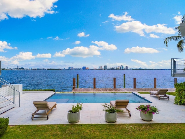 view of swimming pool featuring a water view and a dock