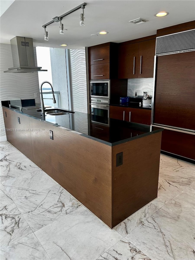 kitchen with modern cabinets, marble finish floor, ventilation hood, and built in appliances