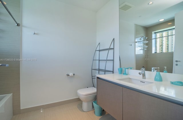 bathroom with tile patterned floors, vanity, toilet, and a shower
