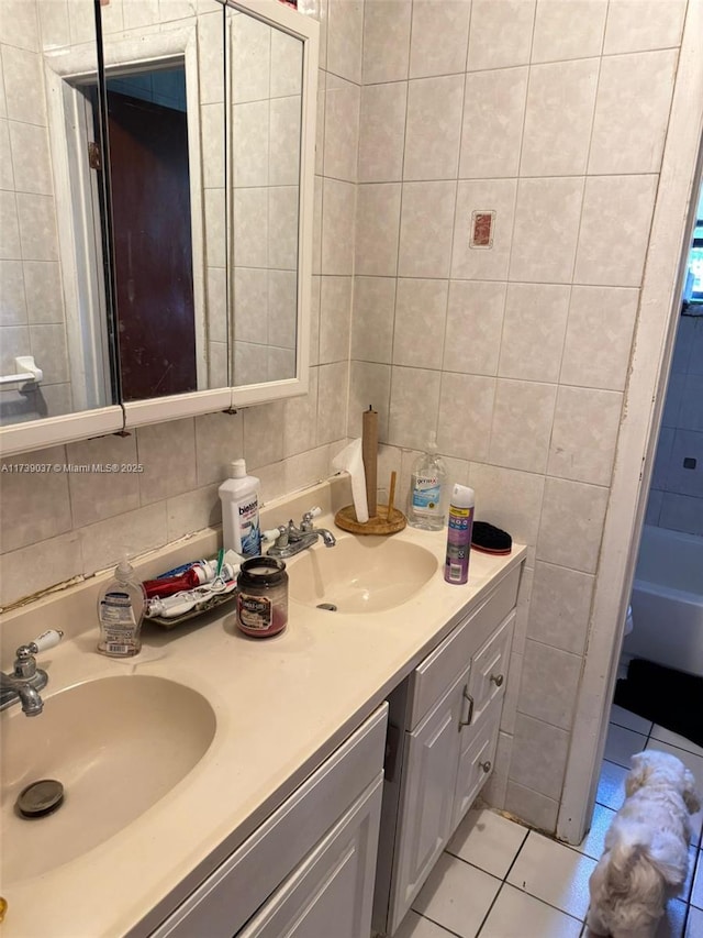 bathroom with tile walls, vanity, tile patterned flooring, decorative backsplash, and a washtub