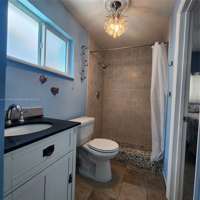 full bathroom with vanity, stone finish flooring, a tile shower, and toilet