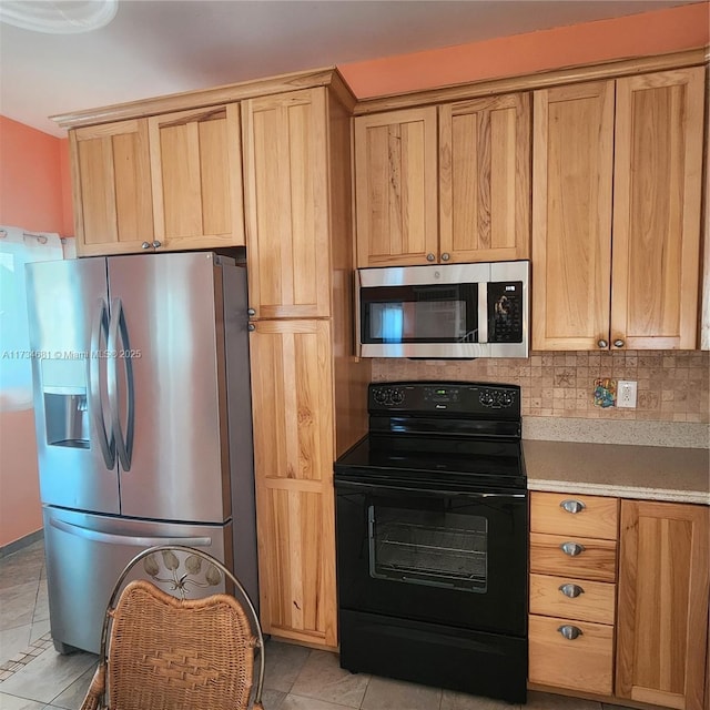 kitchen with light tile patterned floors, appliances with stainless steel finishes, tasteful backsplash, and light countertops