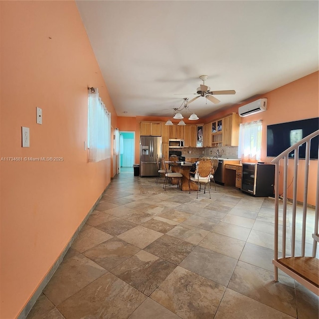 living area featuring a ceiling fan, baseboards, stone finish flooring, and a wall mounted air conditioner