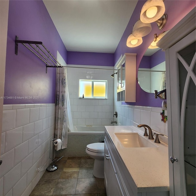 bathroom with tile walls, tiled shower / bath, vanity, and toilet