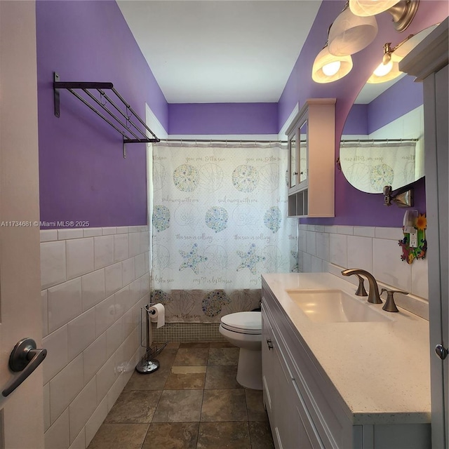 bathroom with vanity, toilet, tile walls, tile patterned floors, and shower / bath combo