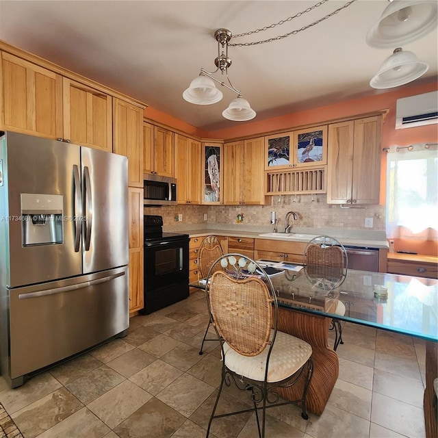 kitchen featuring appliances with stainless steel finishes, glass insert cabinets, a sink, and tasteful backsplash