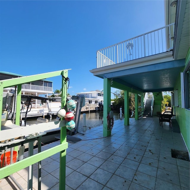 view of dock featuring a patio, a water view, and stairway